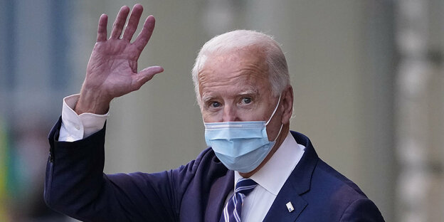Ein Maske tragender Joe Biden winkt in die Kamera