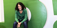Bettina Jarasch sitzt auf einem grünen Möbelstück