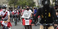 Radfahrer mit Protestplakaten und peruanischer Fahne