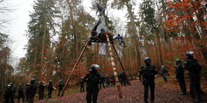 Polizeibeamte vor einer Dreibein-Plattform im Dannenröder Forst