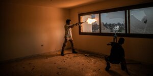 Ein libyischer Kämpfer schießt mit seinem Sturmgewehr aus einem Fenster hinaus