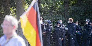Demonstrant mit Deutschlandfahne, im Hintergrund Polizisten