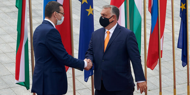 Polens Ministerpräsident Mateusz Morawiecki und Ungarns Regierungschef Viktor Orban schütteln sich die Hand