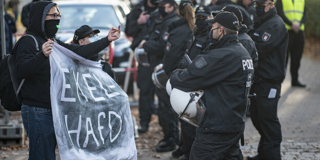 Menschen demonstrieren an einer Polizeiabsperrung mit einem Banner mit der Aufschrift "EKELHAFD" gegen die Aufstellungsversammlung des Hamburger AfD-Landesverbandes für die Landesliste zur Bundestagswahl 2021.