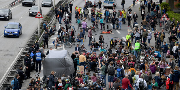 Demonstranten blockieren bei einer Protestaktion gegen Autoverkehr den Theodor Heuss Ring in Kiel.