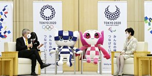 Thomas Bach, zwei Olympiamaskottchen und die Gouverneurin von Tokio auf einem Podium