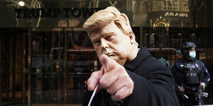 Ein Mann mit Trump-Maske steht vor dem Trump Tower in New York