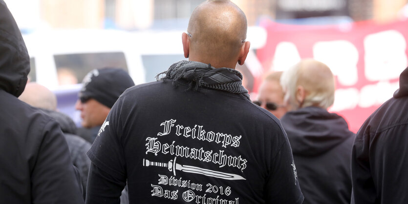 ein Rechtsradikaler mit einem Palästinensertuch und einem Pulli, auf dem Freikorps Heimatschutz steht