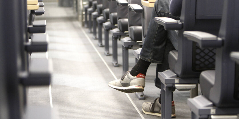 Die Beine eines Fahrgasts auf einem Sitzplatz im ICE.