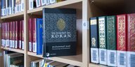 ein Koran steht in einem Bücherregal