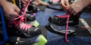 Eislaufschnürschuhe in Großaufnahme: Die Frauen Eisbären Juniors spielen hier mit rosa Schnürsenkel als Zeichen gegen Brustkrebs