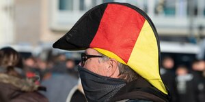 Ein Mann mit Napoleon-Hut in den Farben der deutschen Flagge