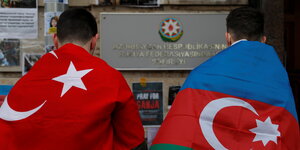 Zwei Männer mit aserbaidschanischer unn Türkischer Flagge trauern nahe der Botschaft von Aserbaidschan in Moskau