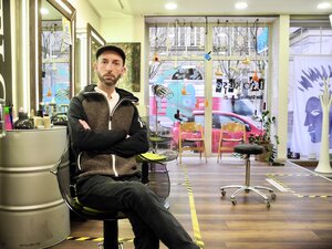 Friseur Benjamin Walter sitzt in seinem Friseursalon.