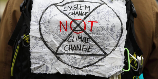 Der Text "System change – not climate change" auf einem Stück Stoff beim Klimastreik Fridays for Future ,