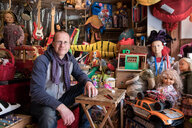 Überall Puppen und Spielzeug: in der Mitte sitzt Philipp Schünemann – er ist Besitzer eines Spielzeugladens in Prenzlauer Berg