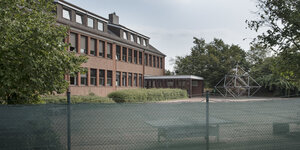 Blick auf den abgezäunten Hof und das trostlose Gebäude der Freien Evangelischen Bekenntnisschule Bremen