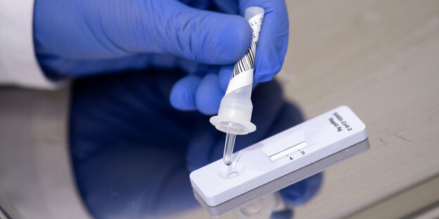 Eine Ärztin zeigt wie der PCR Corona-Schnelltest funktoniert