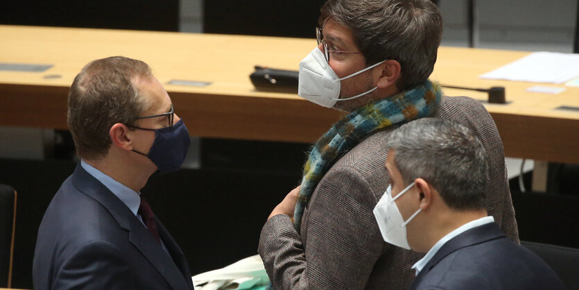 Das Foto zeigt den Regierenden Bürgermeister Mciahel Müller von der SPD neben Justizsenator Dirk behrednt von den Grünen, Am rechten Bildrand steht SPD-Fraktionschef Raed Saleh.