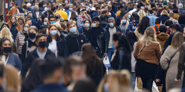 Viele Menschen in einer Fußgängerzone tragen Mund-Nasenbedeckung