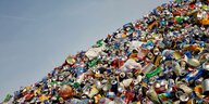 Eine Sammelstelle für Recycling - Viele Aludosen und andere Verpackungsmaterialien liegen vor blauem Himmel auf einem haufen.