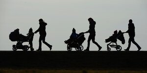 drei Frauen mit Kinderwagen als Schattenriss zu erkennen