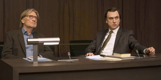 Zwei Männer sitzen in einem Gerichtssaal im ARD-Film "Gott"