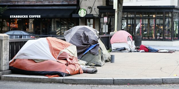 Zelte von Obdachlosen auf einem Bürgersteig vor einem Starbucks