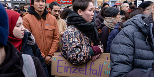 Auf einer Demonstration trägt eine Frau ein Schild mit dem Titel "Einzelfall".