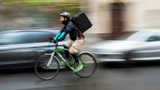 Mann fährt auf einem Fahrrad mit Rucksack