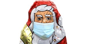 Schokoladenweihnachtsmann mir Mundschutzmaske