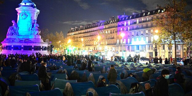 Viele Zelte bedecken einen Platz im Zentrum von Paris bei Nacht.