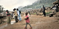 Das Dorf Luvungi in der Demokratischen Republik Kongo : Ein kleines Kind, weitere Personen und ein Soldat auf der Strasse.