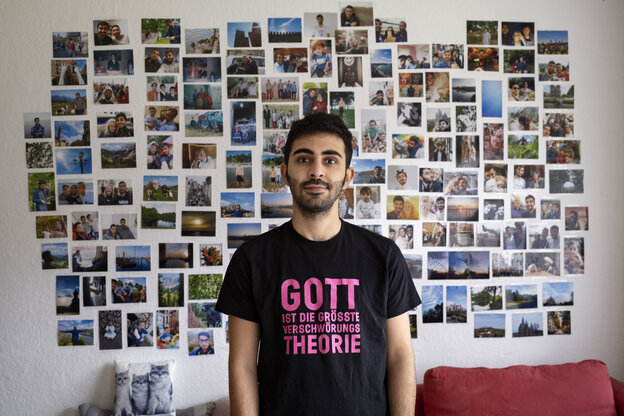 Amed Sherwan vor einer Fotowand trägt ein T-Shirt mit der Aufschrift 