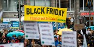 Demonstration mit gelbem Banner mit der Aufschrift "Black Friday Climate not for sale"