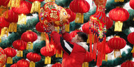 Ein Mann hängt rote Laternen anlässlich des chinesischen Neujahrsfestes in Peking auf