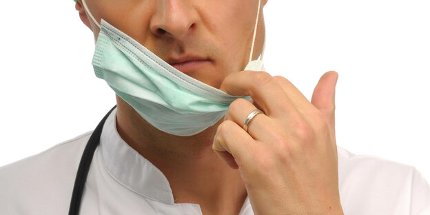 Ein Arzt zieht sich seinen Mund-Nasenschutz herunter