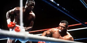 Boxer Mike Tyson taumelt zu Boden, sein Gegner beobachtet ihn dabei