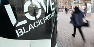 "Love Black Friday"-Schild und einen vorbeieilende Person
