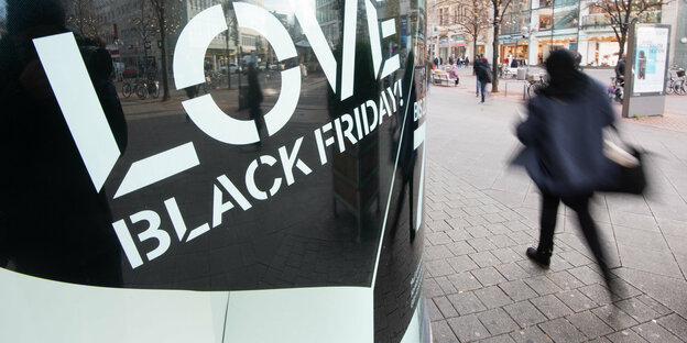 "Love Black Friday"-Schild und einen vorbeieilende Person