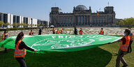 Kunstaktion von Fridays For Future vor dem Reichstag in Berlin zum 5. globalen Klimastreik im April - AktivistInnen rollen ein großes Transüarent mit dem Friday Fror Future Logo aus