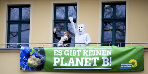 Eine Demonstrantin und eine weitere Person mit Eisbär-Kostuem auf dem Balkon der Geschaeftszentrale von der Partei Buendnis 90/Die Gruenen, mit Transparent "Es Gibt Keinen Planet B"