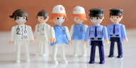 Eine limitierte Auflage von Spielzeugfiguren aus Tschechien, die Krankenschwestern, Ärztinnen und Polizisten mit Mundschutz darstellen, stehen nebeneinander