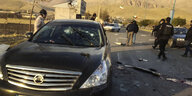 Das Auto in dem der Ermordete sass, steht auf der Straße umringt von Männern