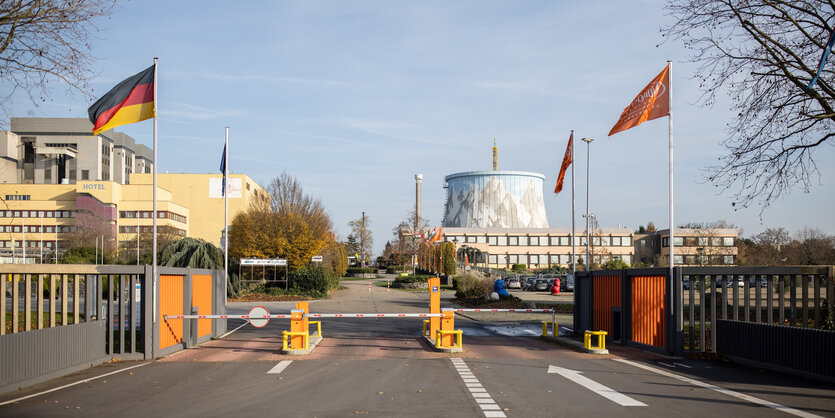 Ein Kühlturm hinter Schranken und Deutschlandfahnen