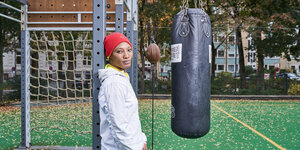 Bintou Schmill steht neben einen Boxsack und einem Punching Ball