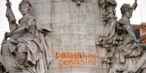 Die Statue de la Republique ist zu sehen, darauf ein Graffito mit der Aufschrift: Darmanin (französischer Innenminister) Rücktritt