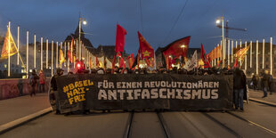 Eine Gruppe von Menschen hält einen schwarzen Banner.