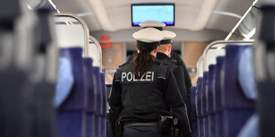 Bundespolizisten kontrollieren in einem ICE und laufen durch die Sitzreihen