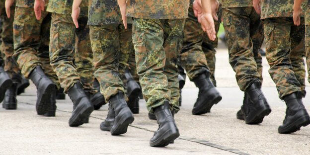 Bundeswehrsoldaten marschieren in Uniform und Kampfstiefeln